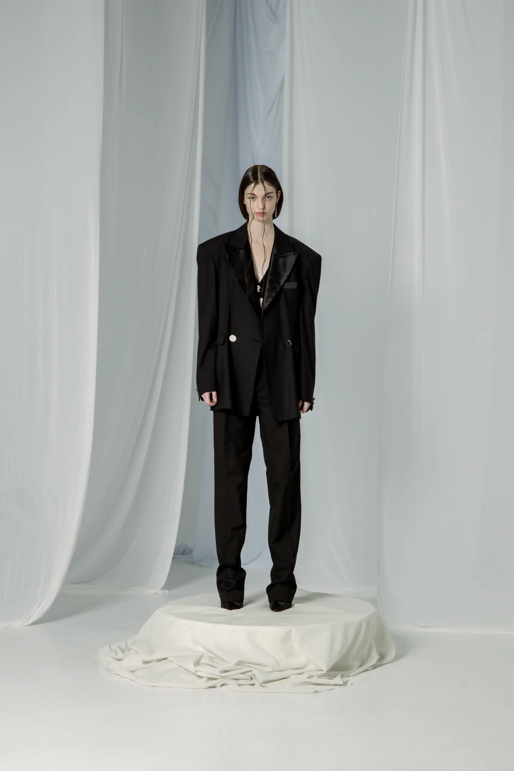 Model u crnom oversize smoking odelu sa satenskim reverima i ravnim pantalonama